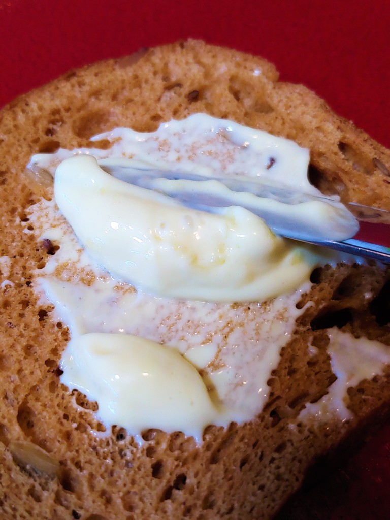 Homemade mayonnaise being spread on a piece of bread
